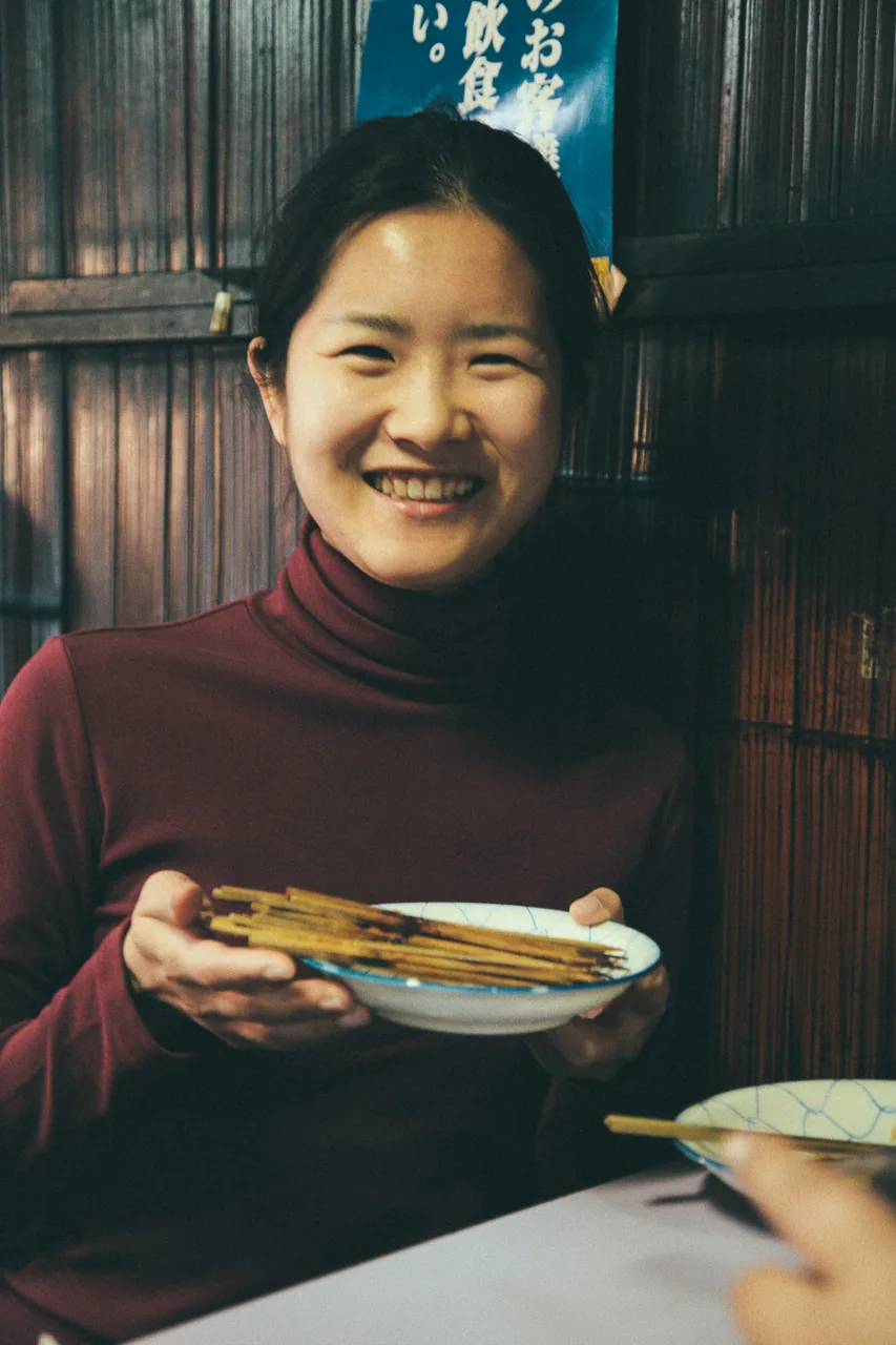 A smile over a plate of yakitori