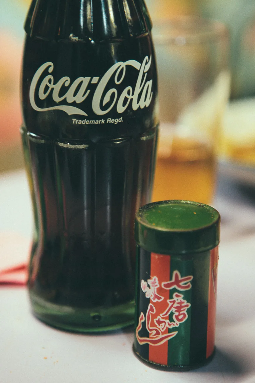 A bottle of Coca-Cola and a tin of shichimi spice