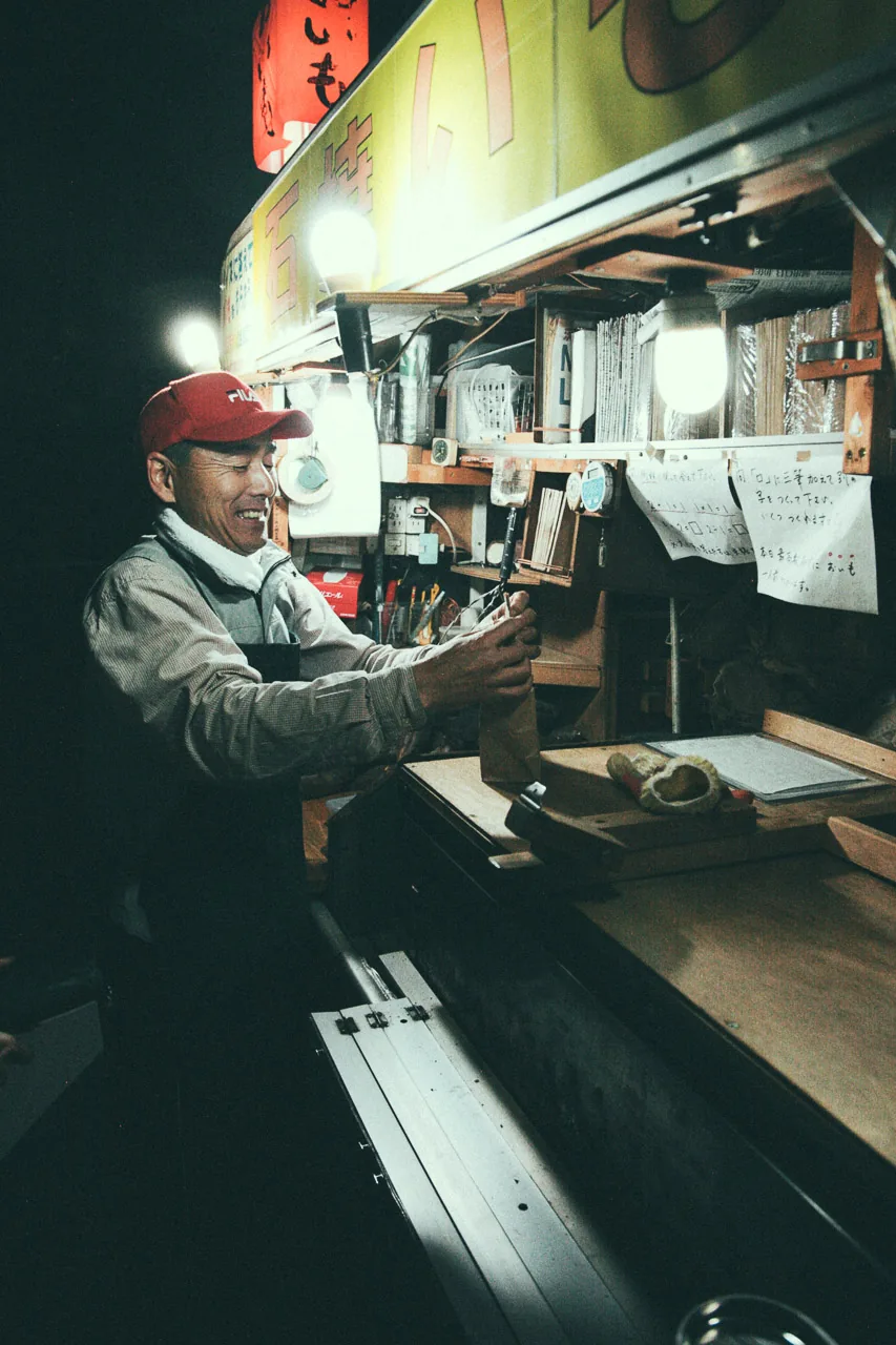 A man at a food stall at night
