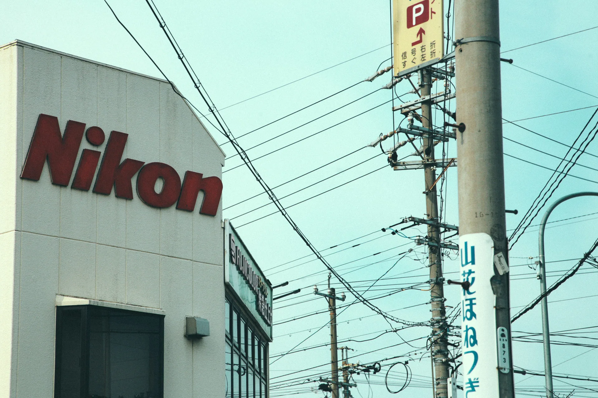A Nikon building behind utility poles