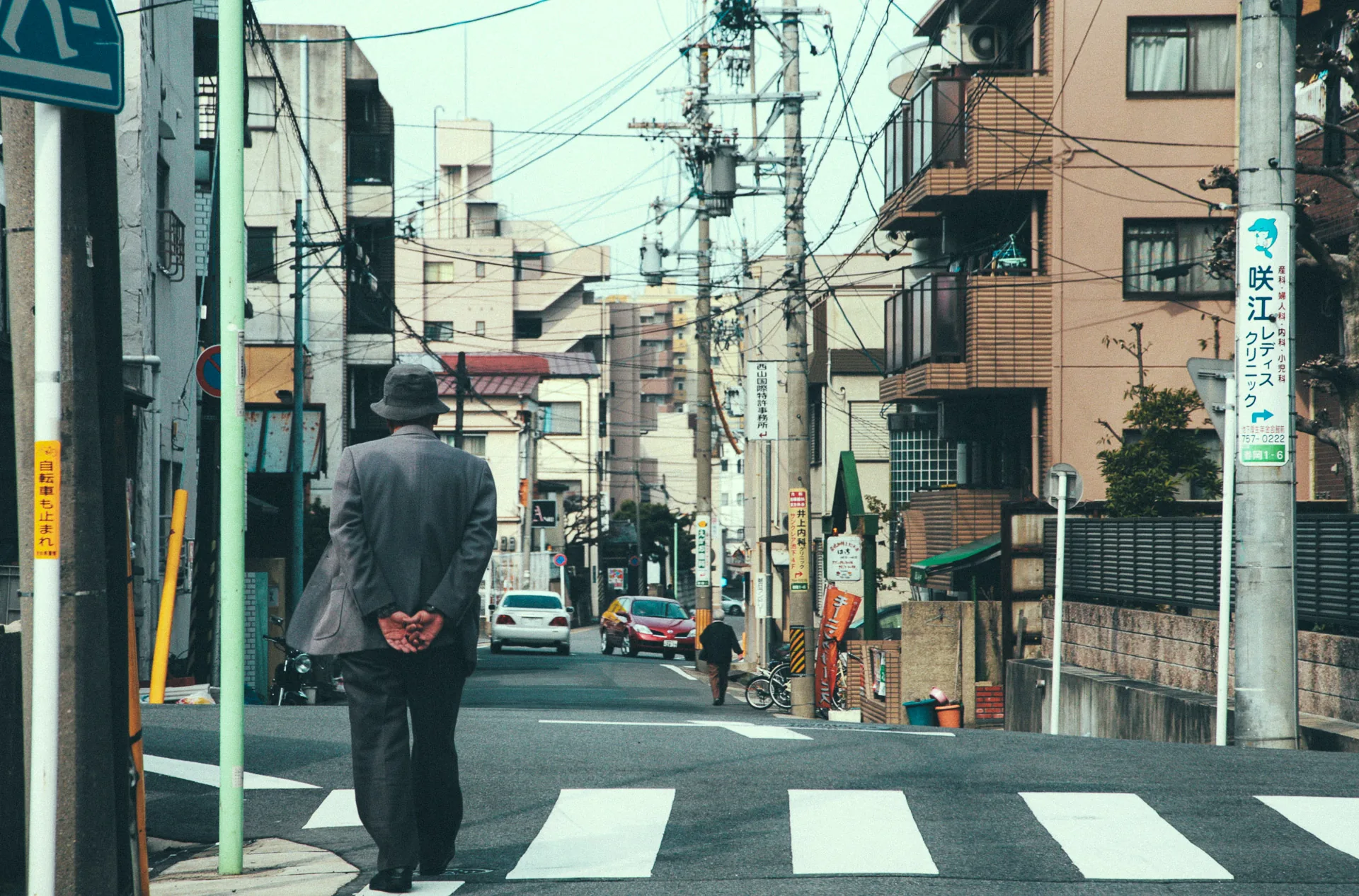 An elderly man crossing a quiet Nagoya street