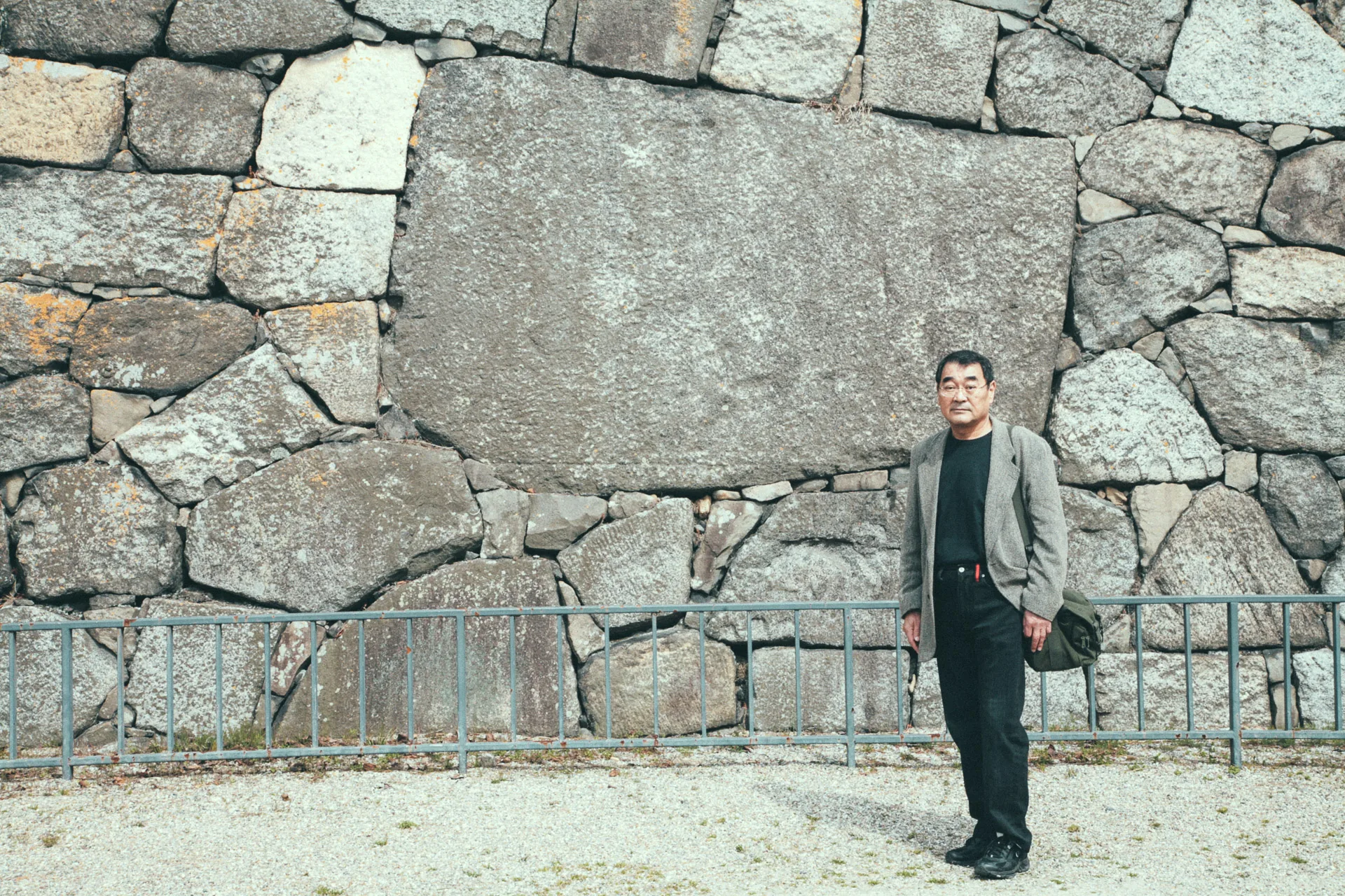 Masao standing beside a huge stone in the castle wall