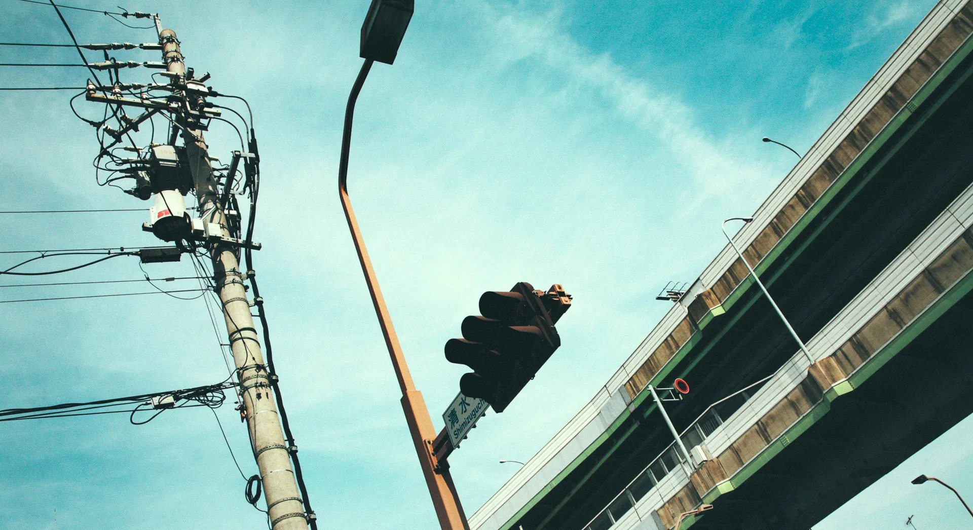 A traffic light and an expressway ramp against the sky