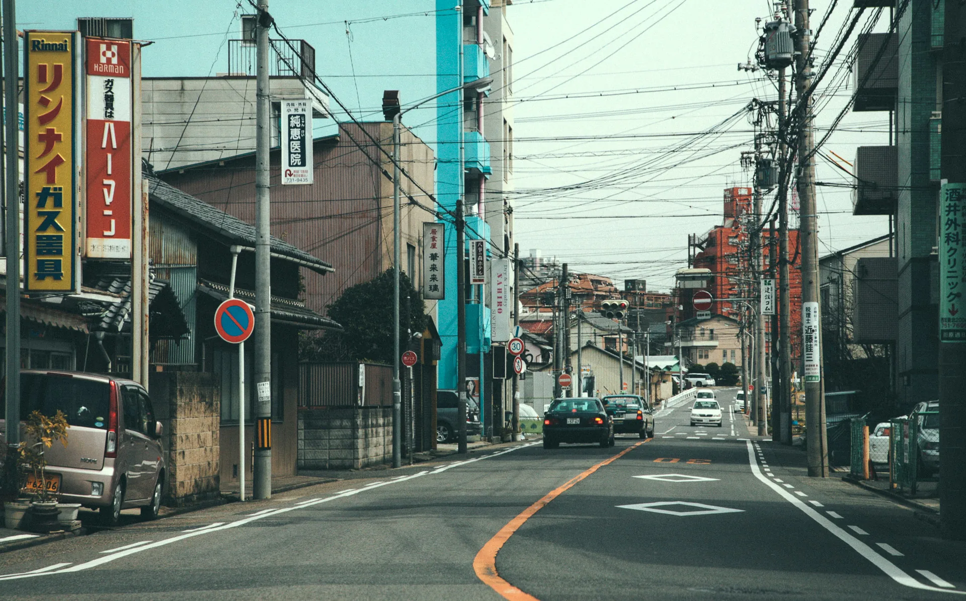 A city street lined with signs and utility wires
