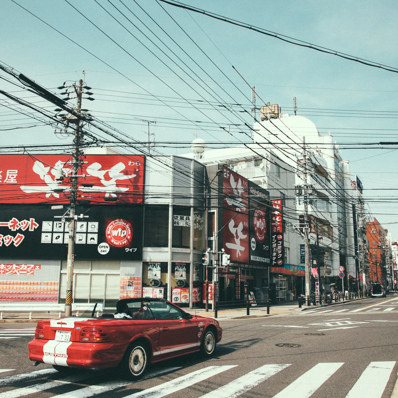 A red convertible at a city intersection