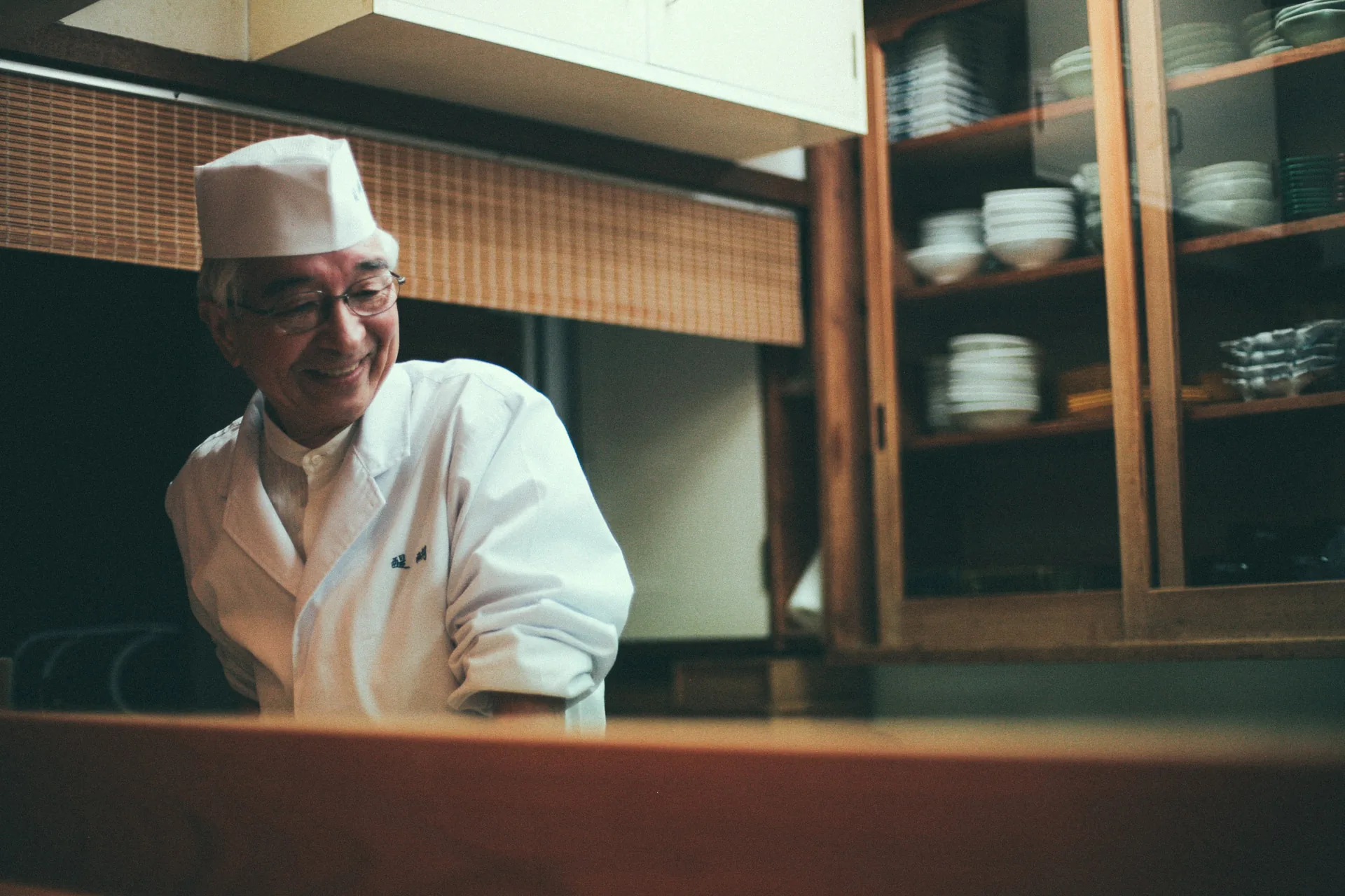 The chef smiling behind the counter