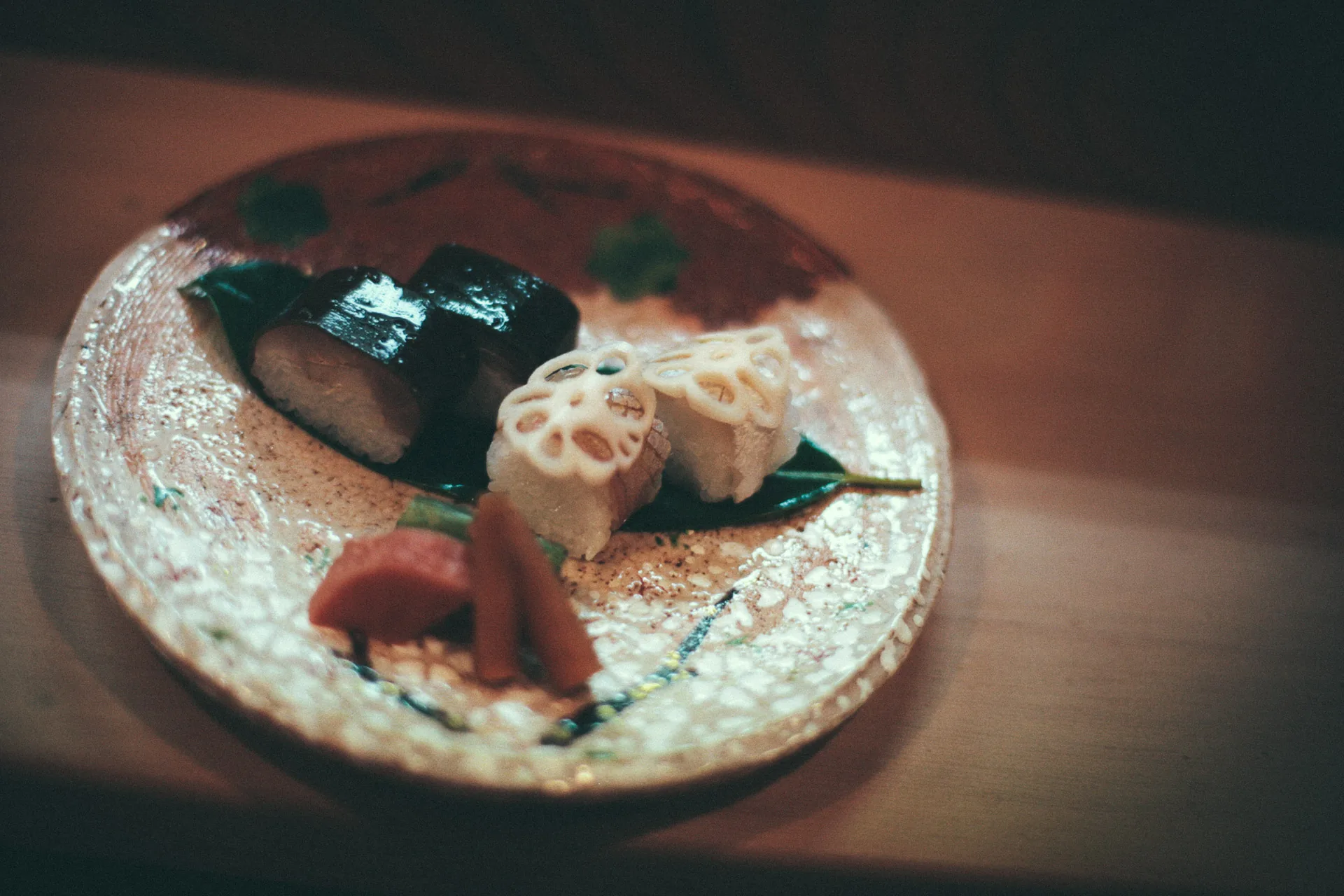Pressed sushi and lotus root on a painted plate