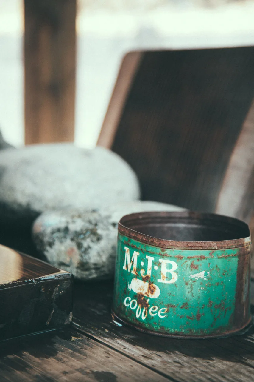 An old coffee tin beside a stone