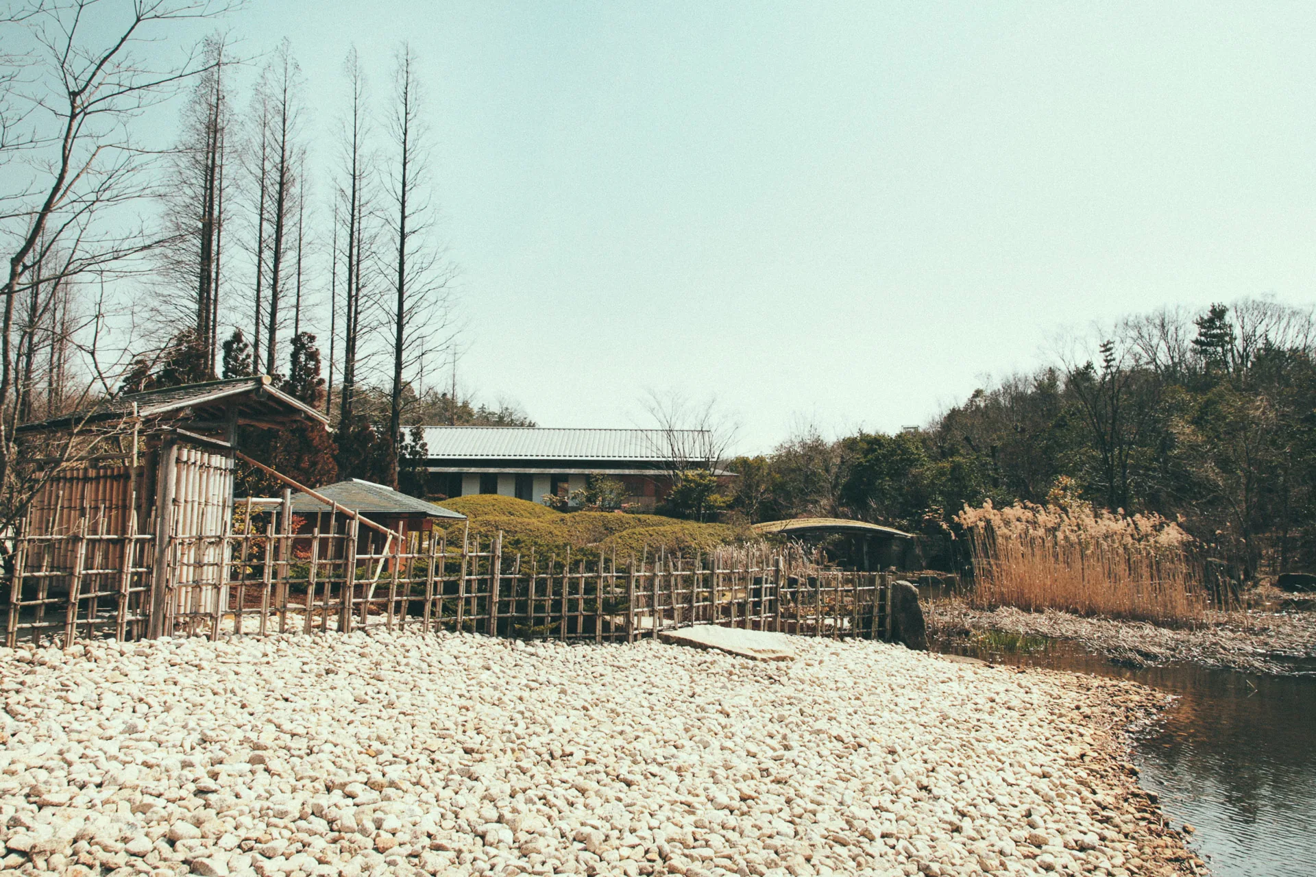 A pebble shore and bamboo fences by the pond