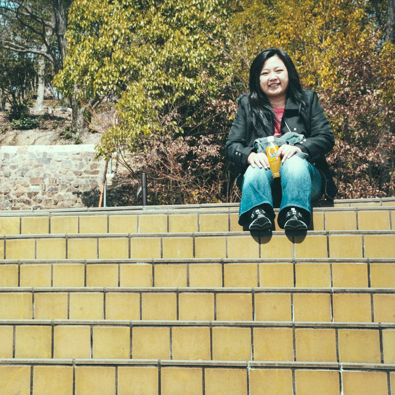 Yasuko sitting on a tiled wall
