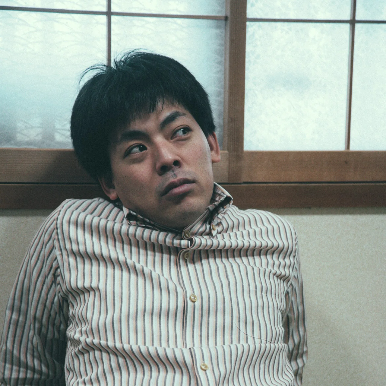 Jutaro leaning against the wall