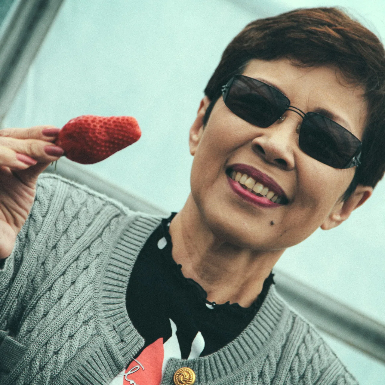 Holding up a big strawberry