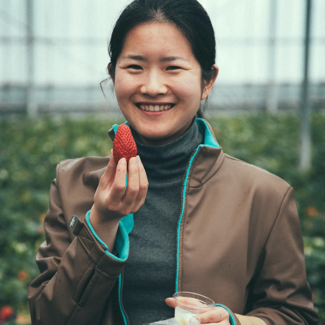 Smiling with a strawberry in hand