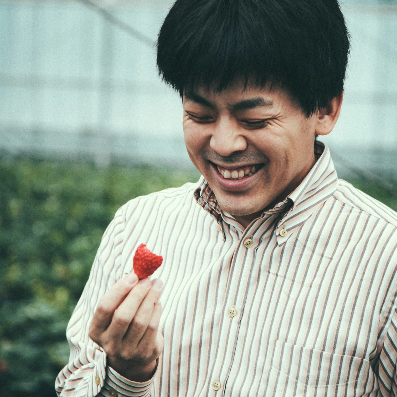 Laughing with a strawberry