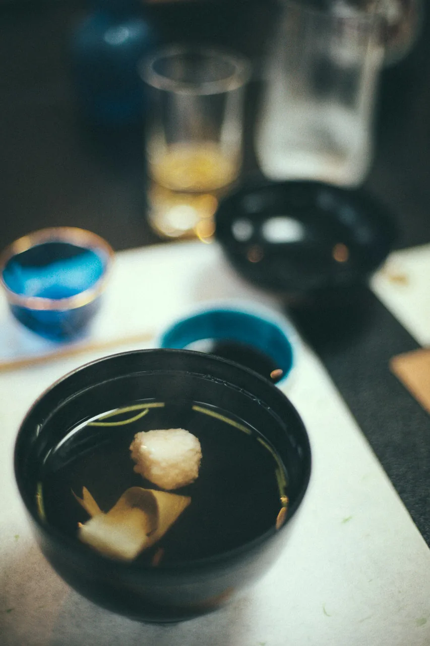 A clear soup in a black lacquer bowl
