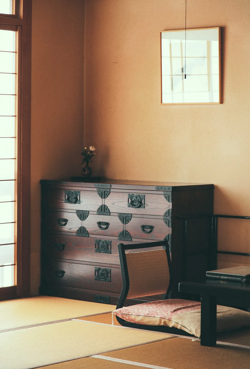 A chest and cushion in the corner of the room