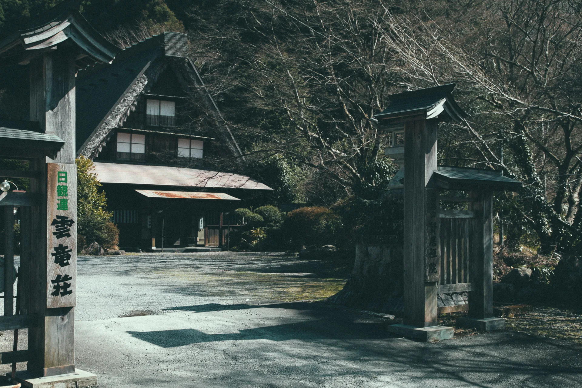 A wooden gate in front of a thatched house