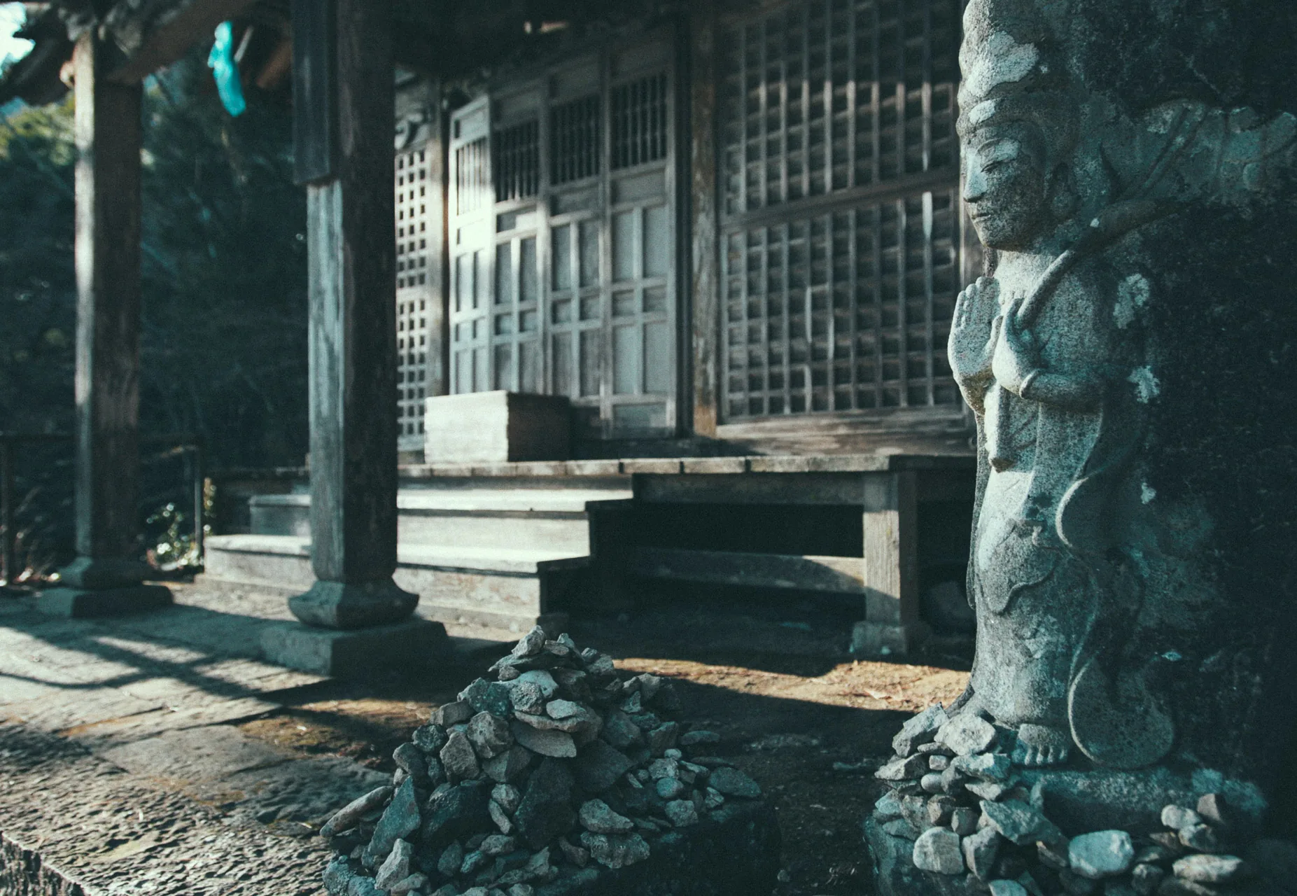 A stone statue beside a wooden hall