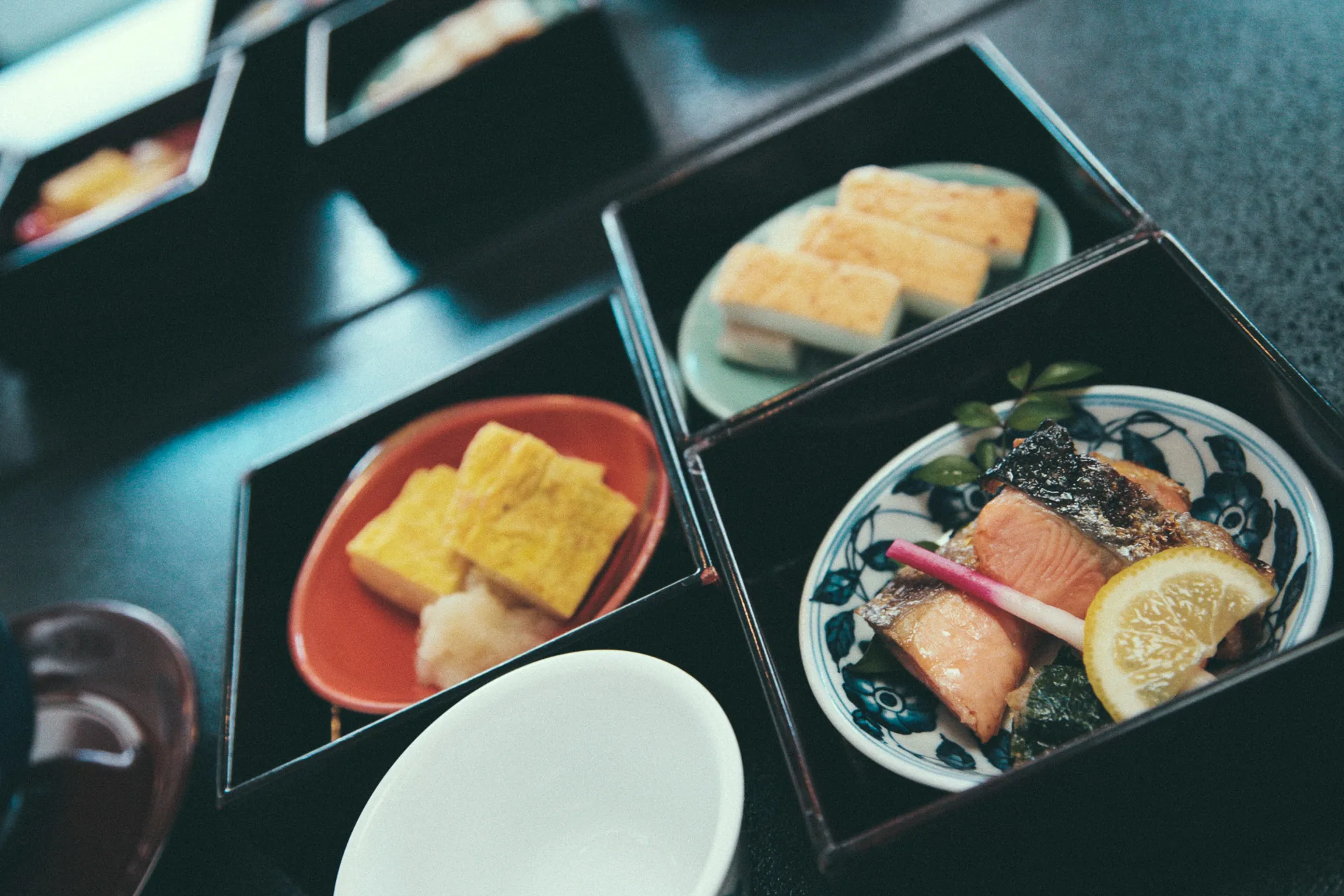 A breakfast box with tamagoyaki and grilled salmon