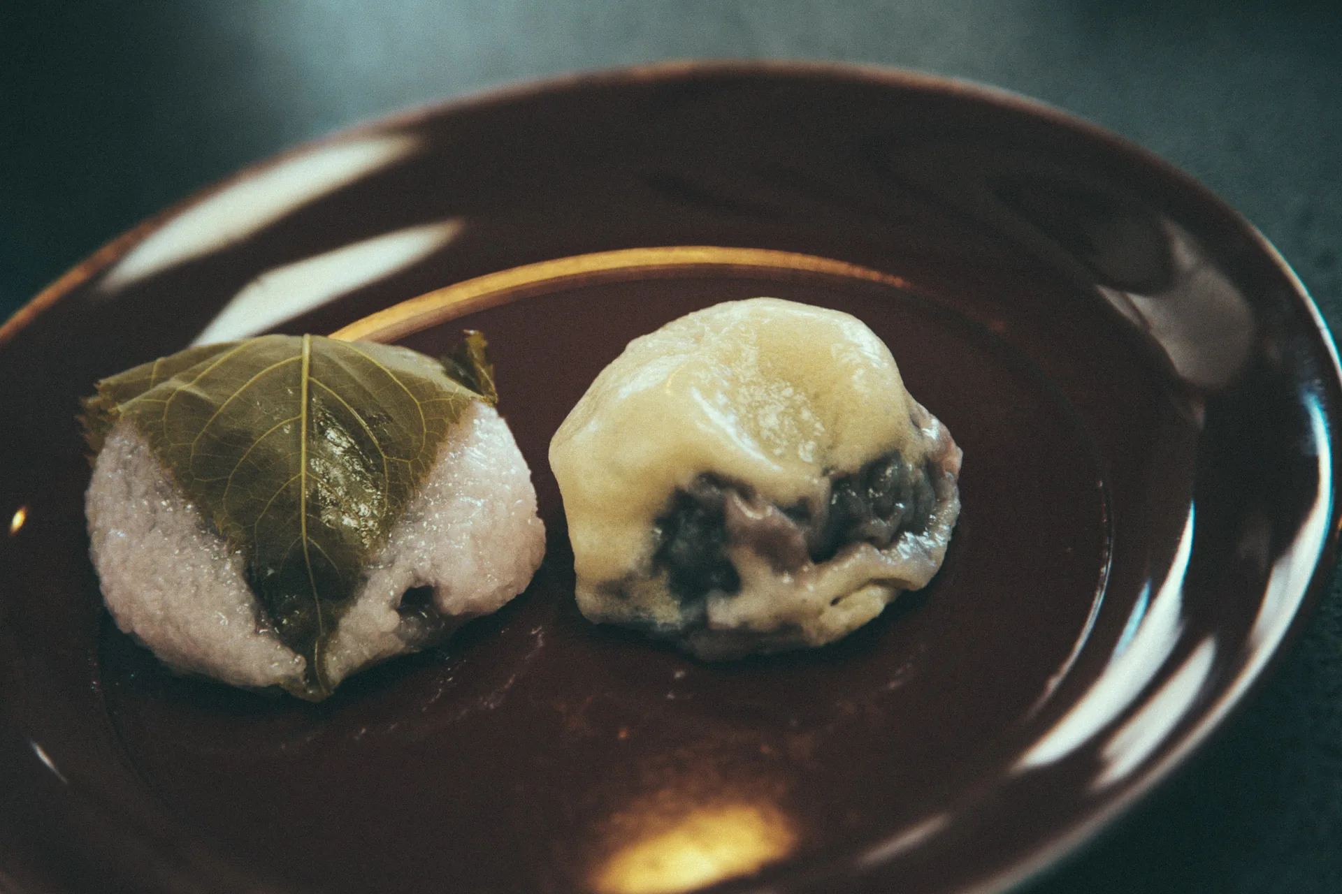 Sakura mochi and a bean-filled sweet on a lacquer plate