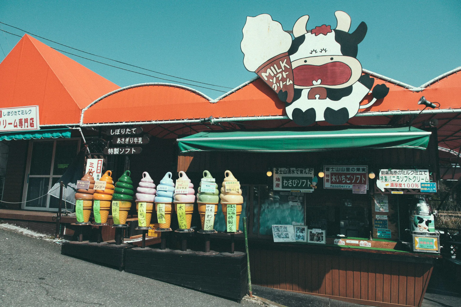 An ice cream stand with a giant cow sign