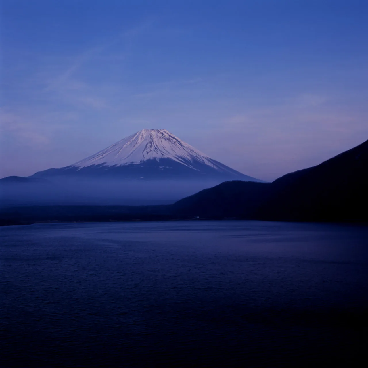 Mount Fuji at dusk above the deep blue water of Lake Motosu, shot on the Hasselblad