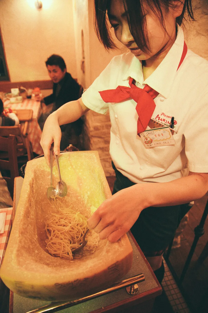 Scraping cheese from the parmesan wheel