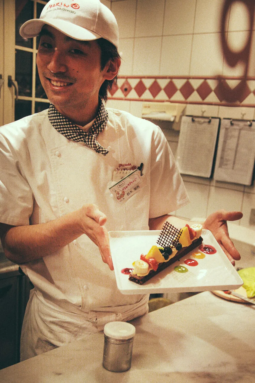 A cook presenting a dessert plate
