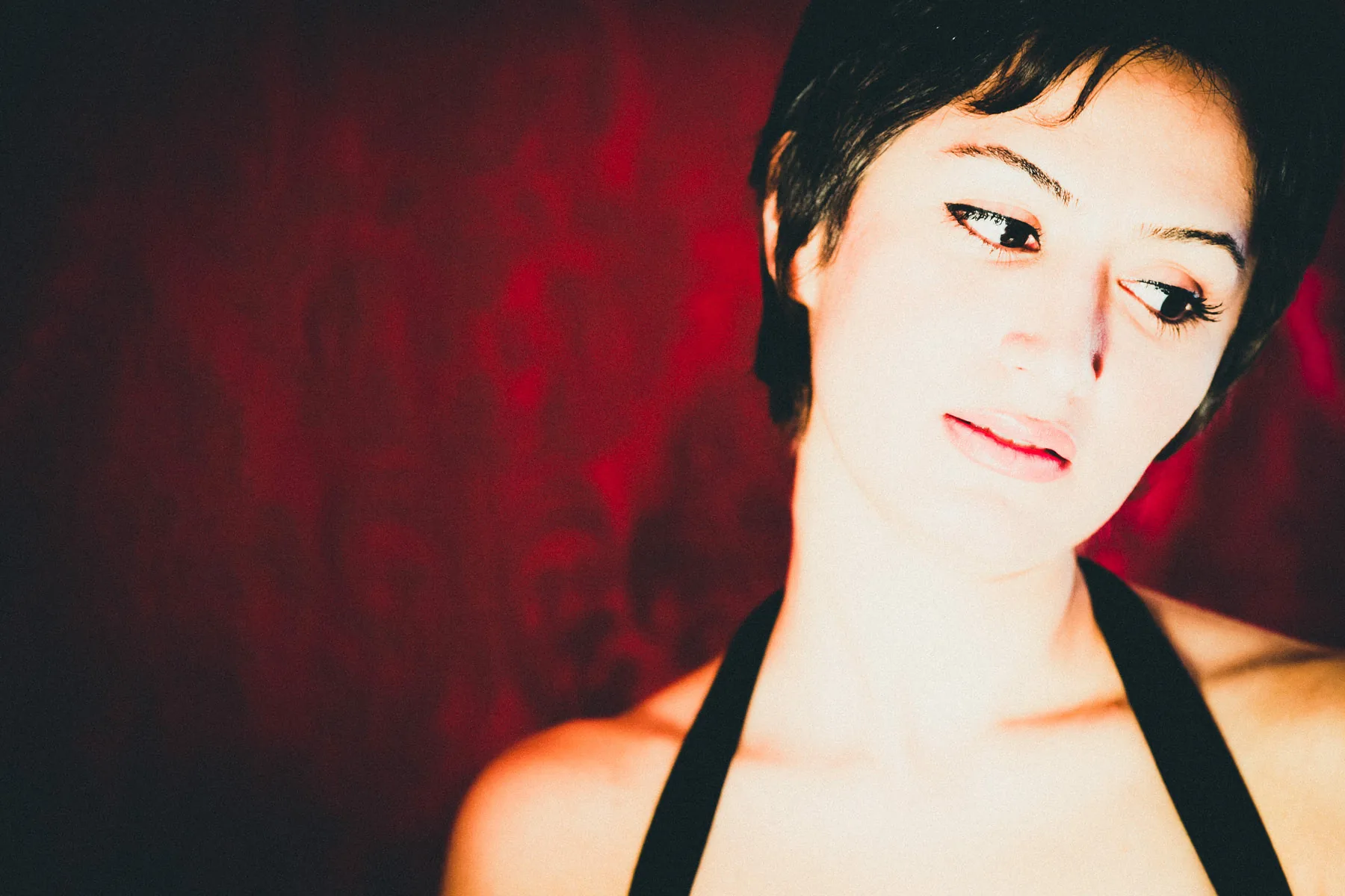 A close-up of the short-haired model against a red backdrop