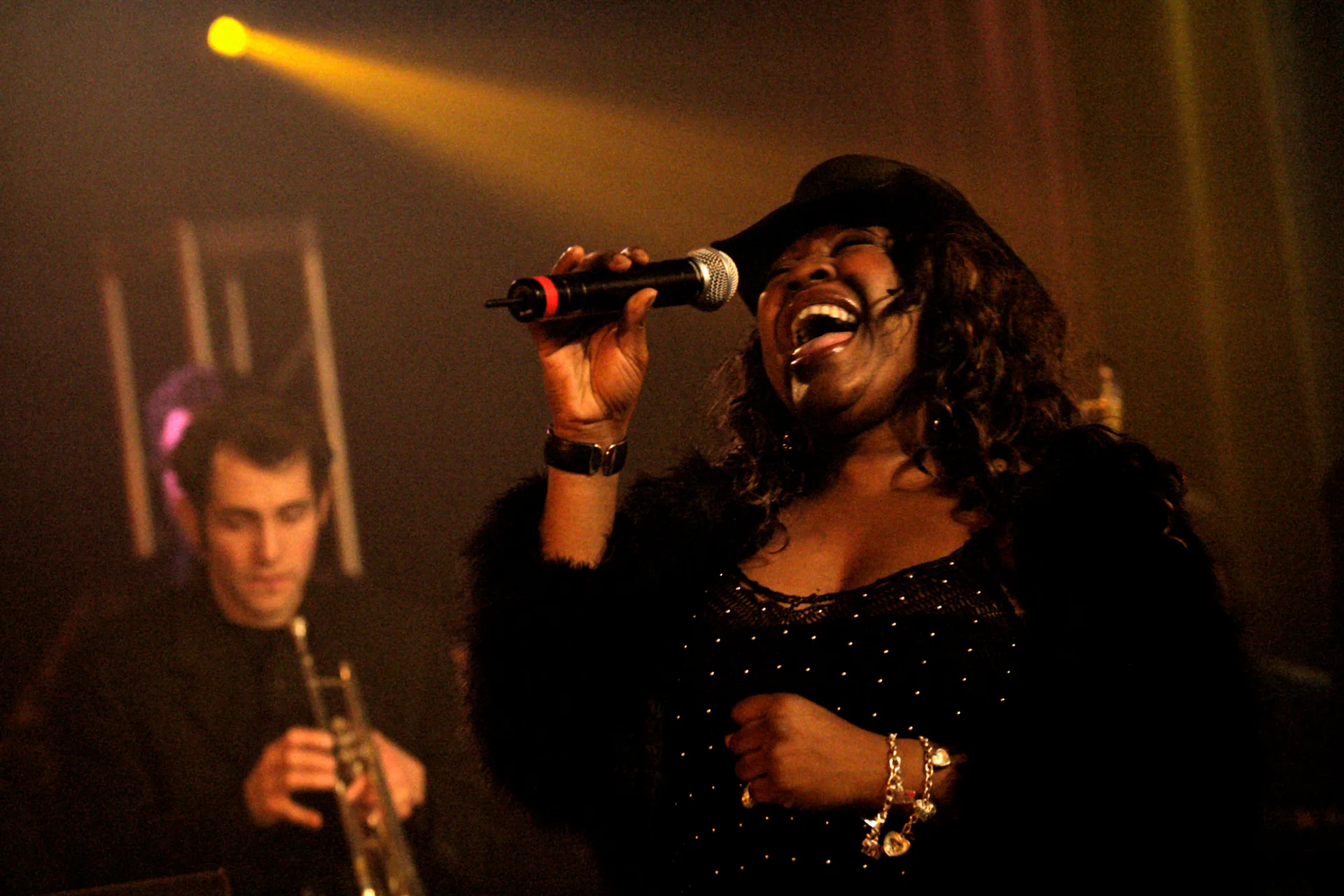 The lead singer belting into the microphone, a trumpeter behind her