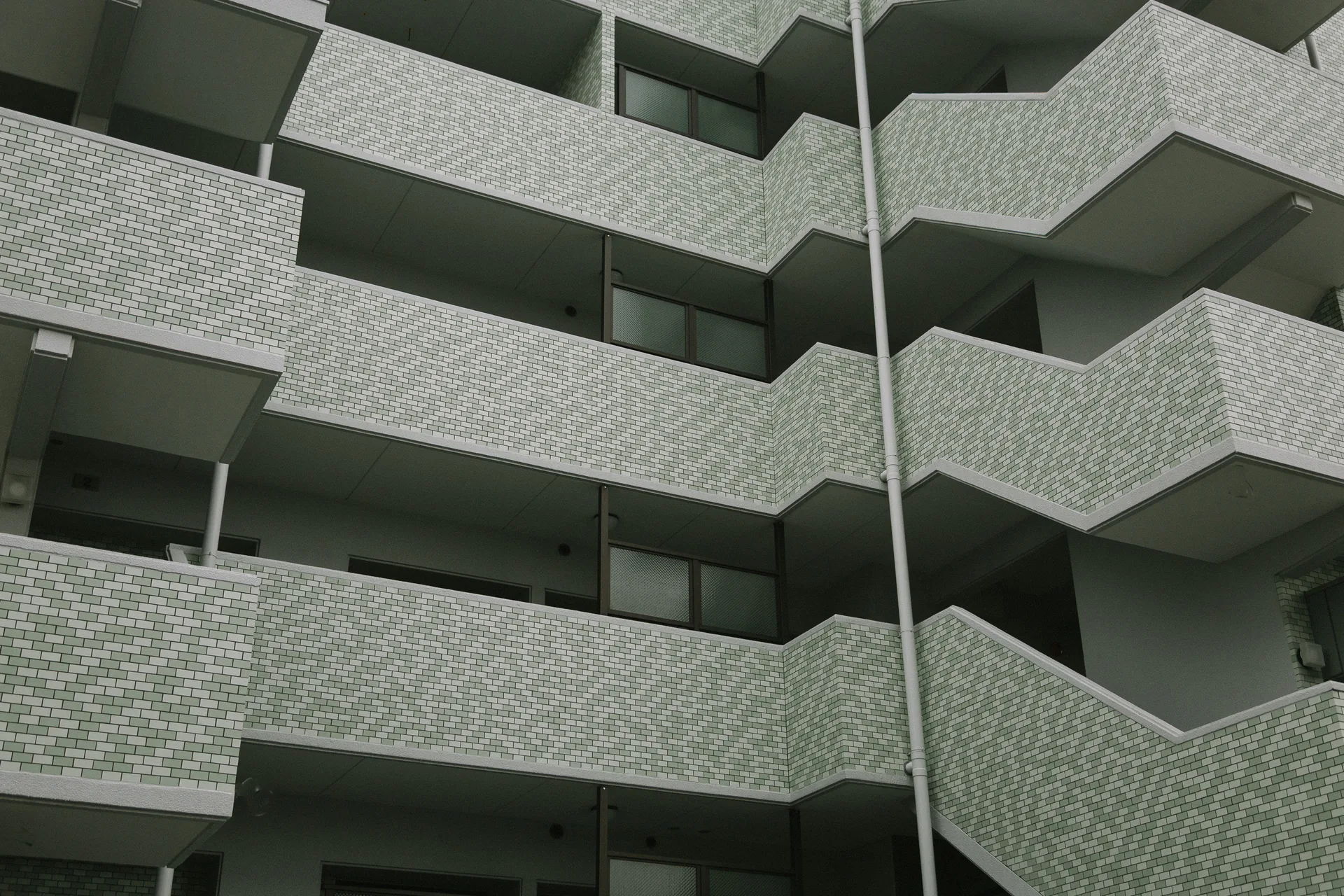 Diagonal balconies of a pale green apartment block