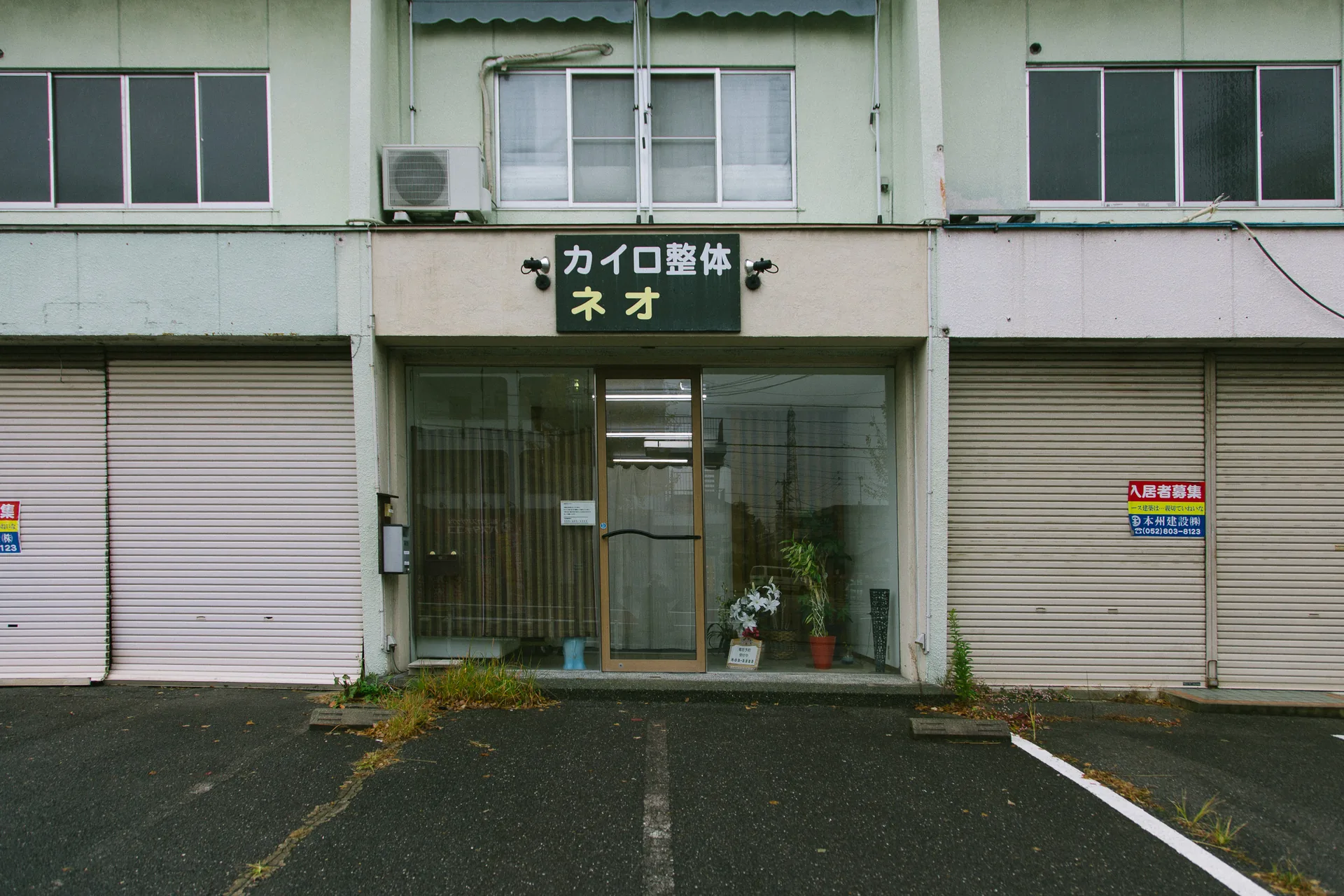A chiropractor’s shopfront between two closed shutters