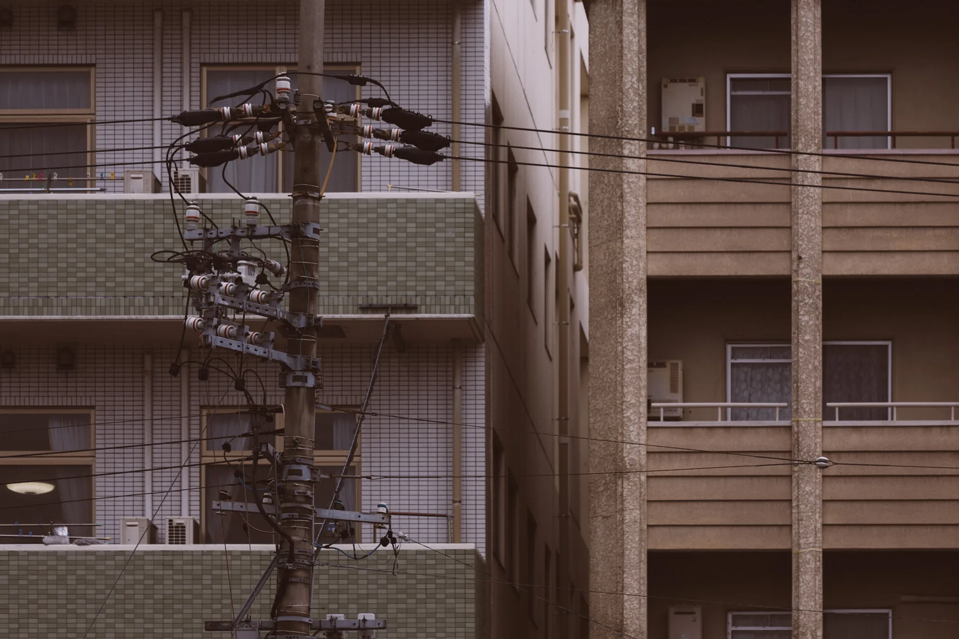 Balconies and tangled wires around a utility pole