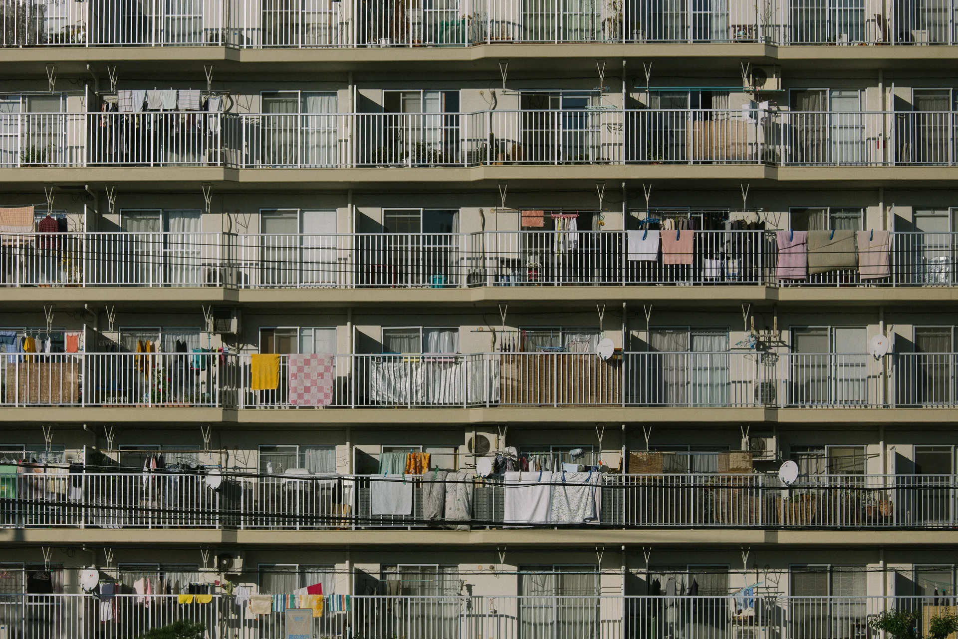 Rows of balconies hung with laundry on an apartment block
