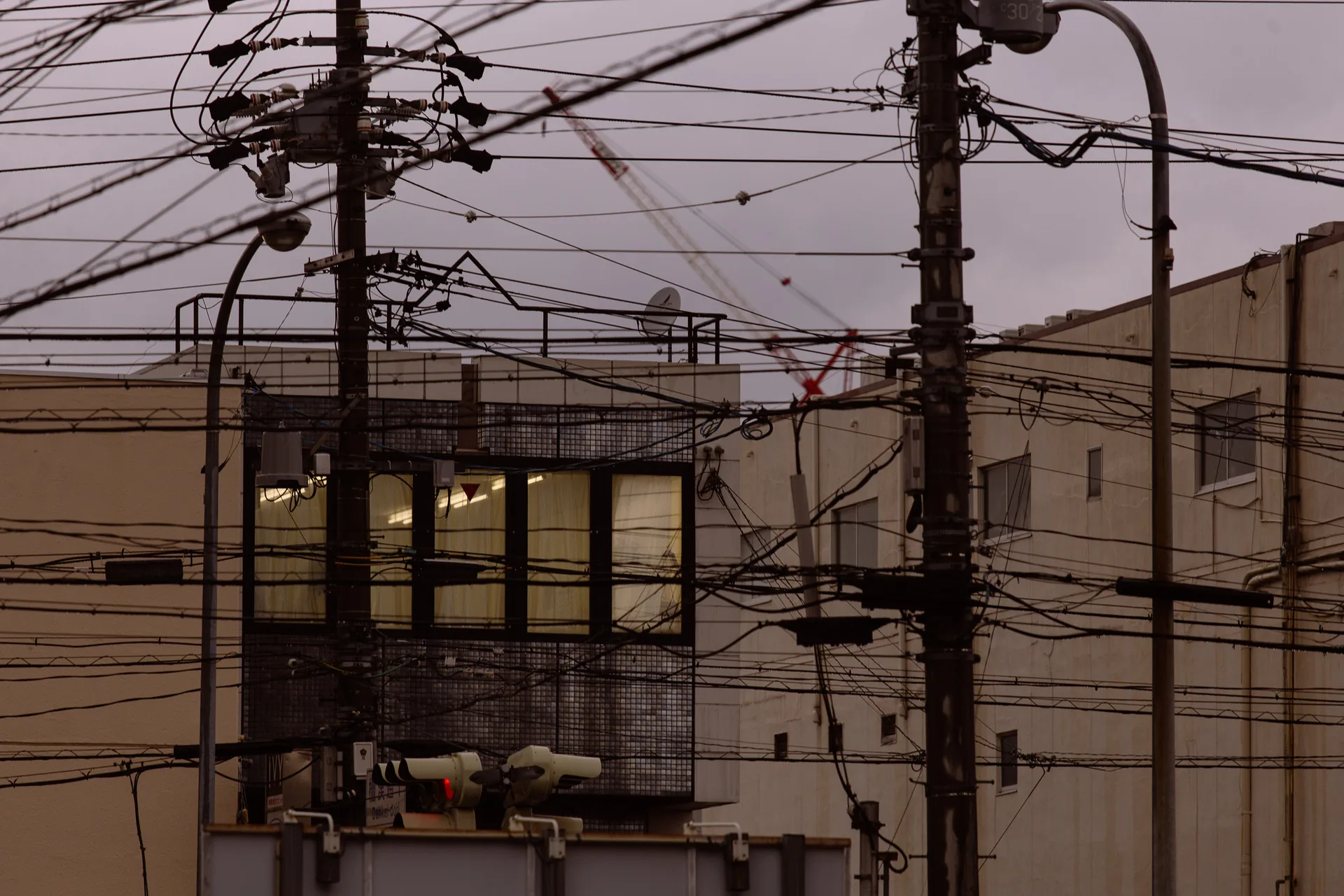 Lit offices behind a tangle of wires