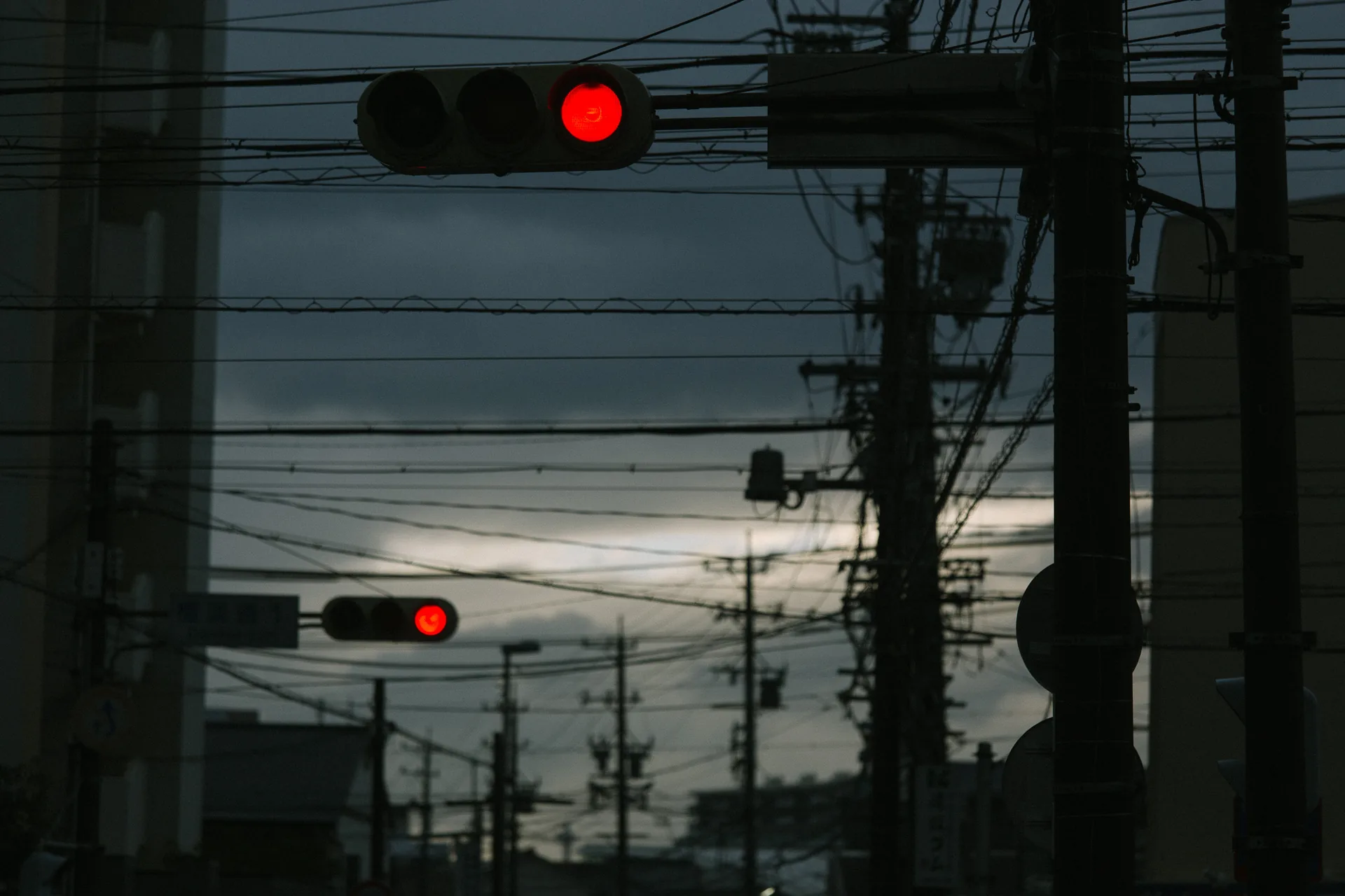 A red traffic light against the sunset
