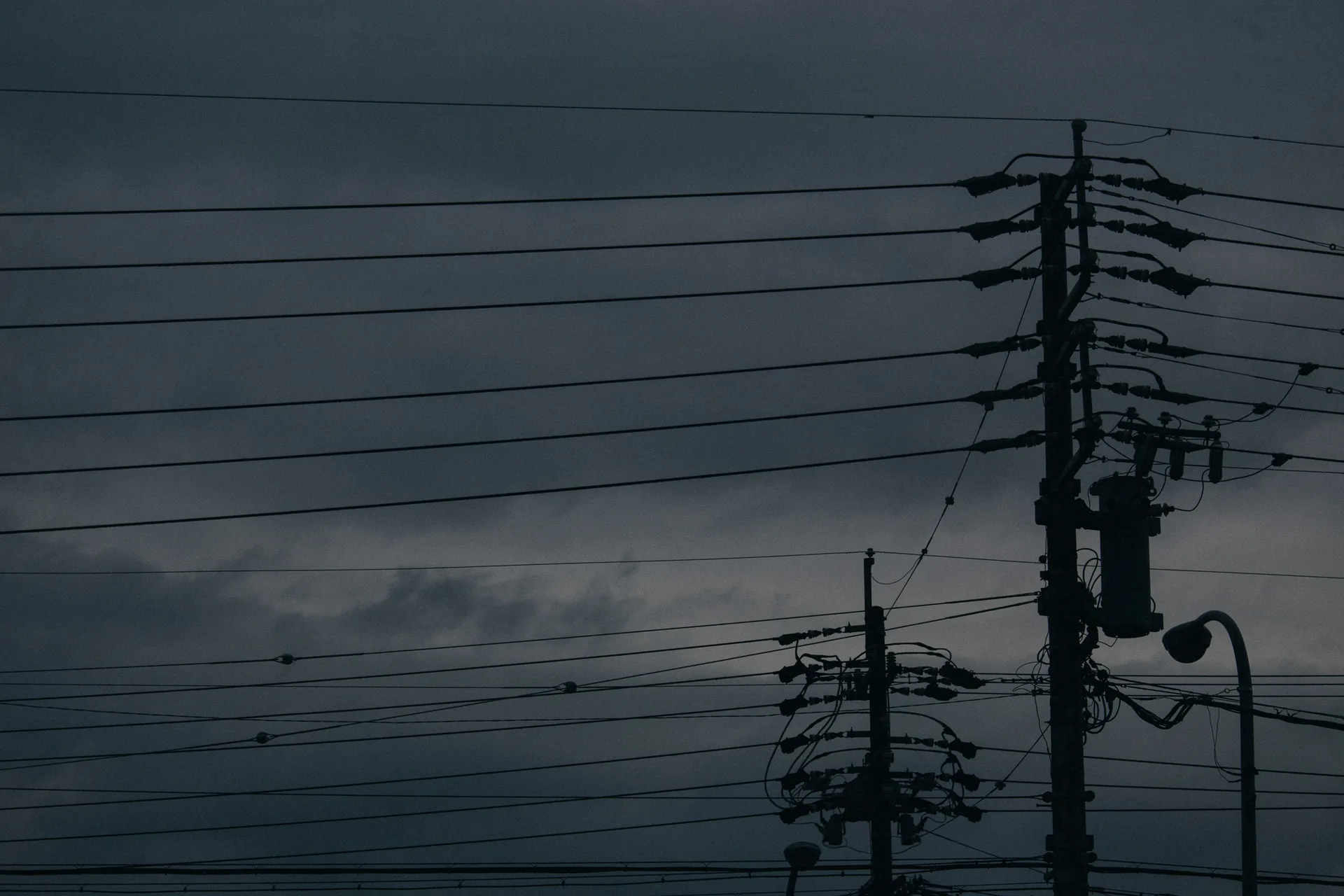 Wires and a street light against a dark sky