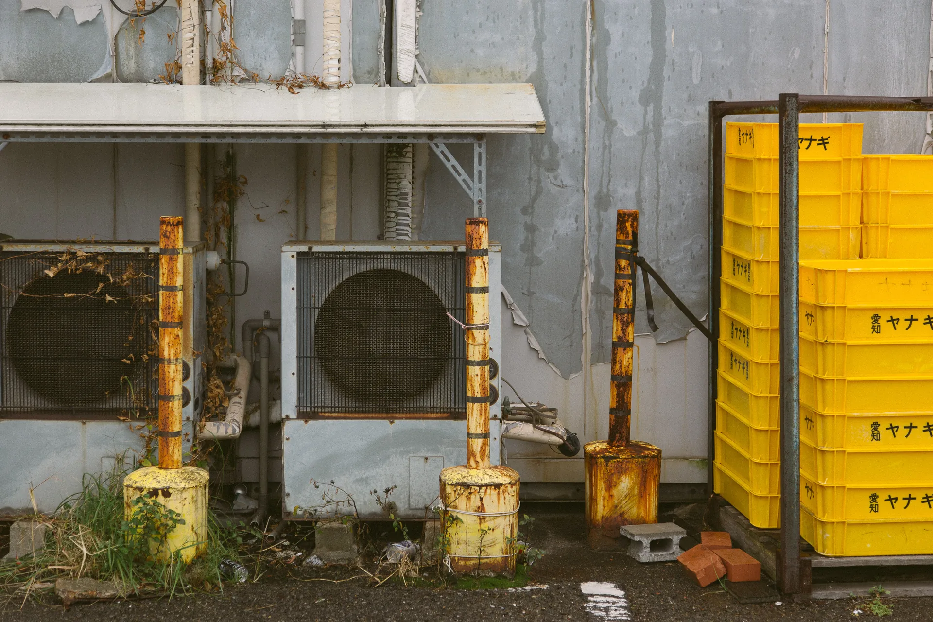 Yellow crates and an air conditioner by a wall