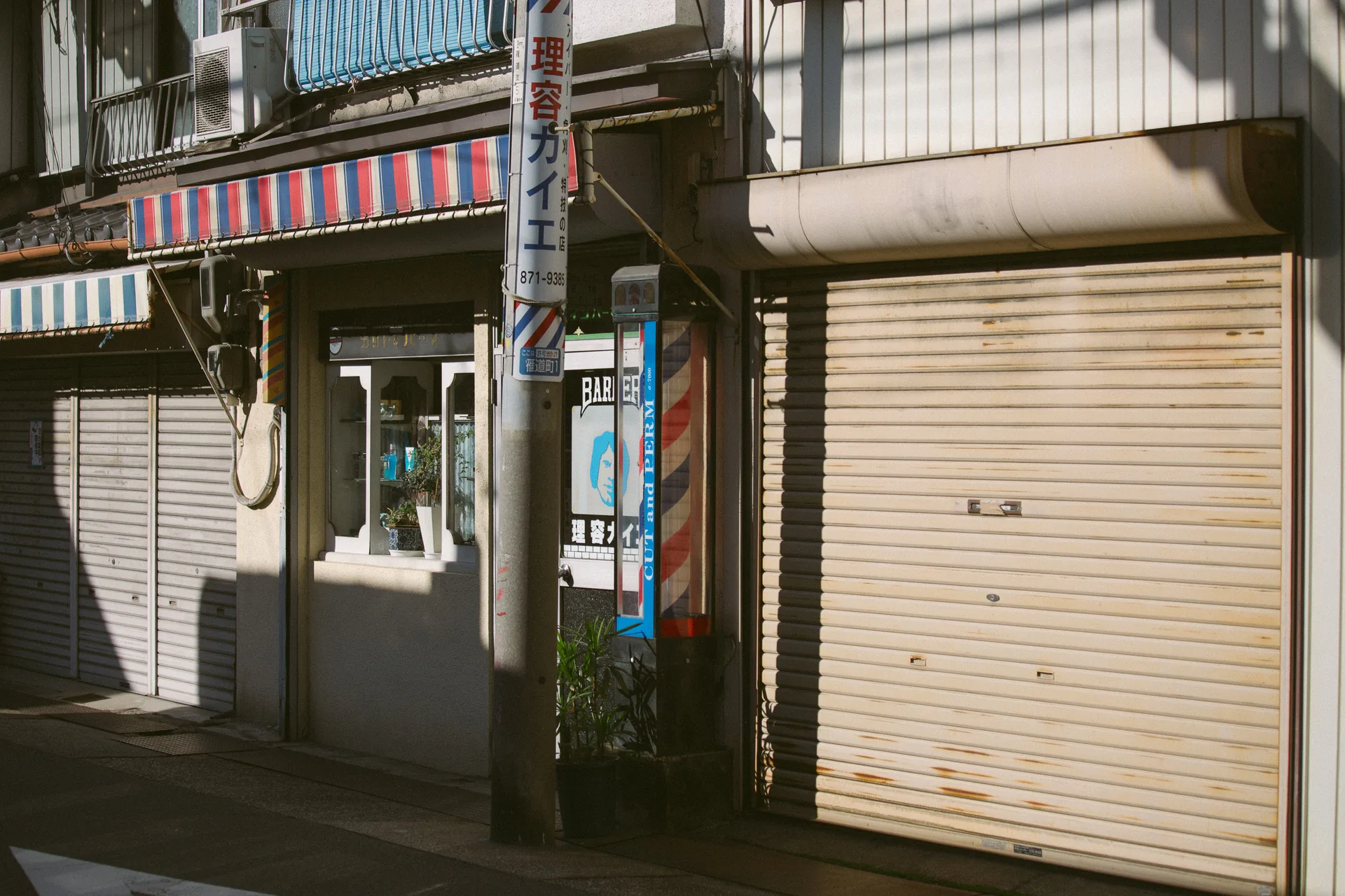 A barber pole beside closed shops