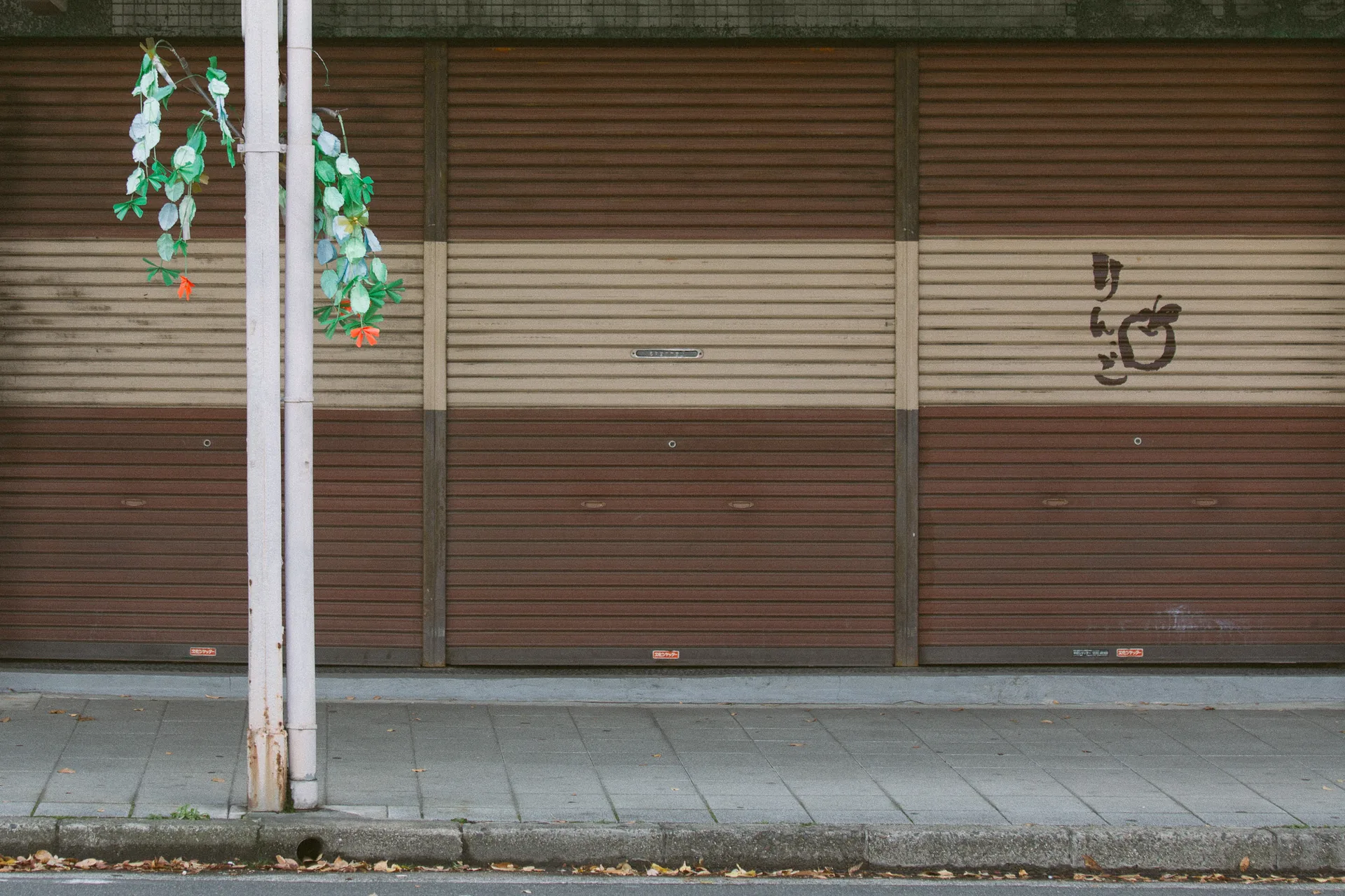 A closed storefront with decorations hanging in front