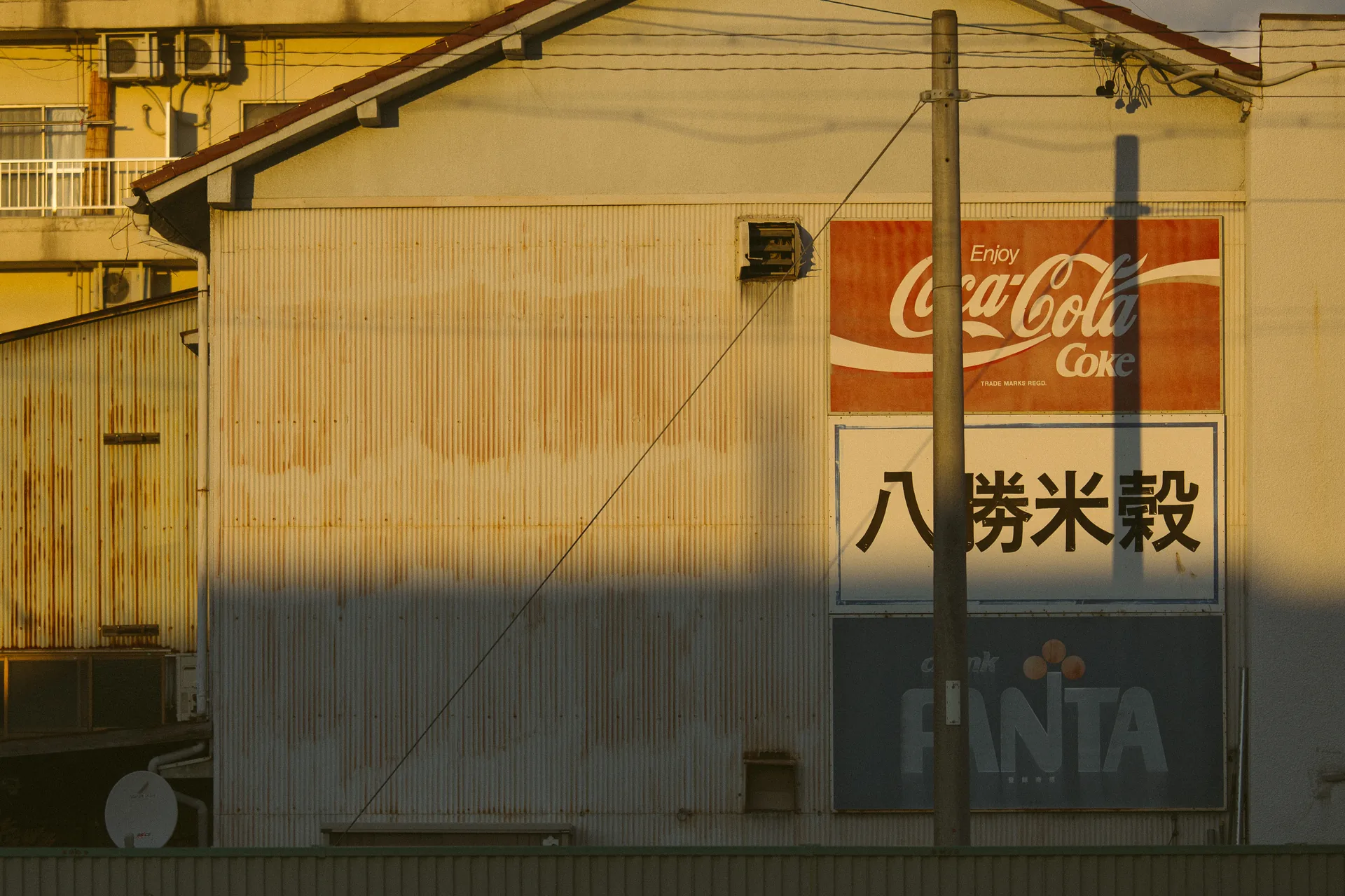 A faded Coca-Cola sign on a sunlit wall