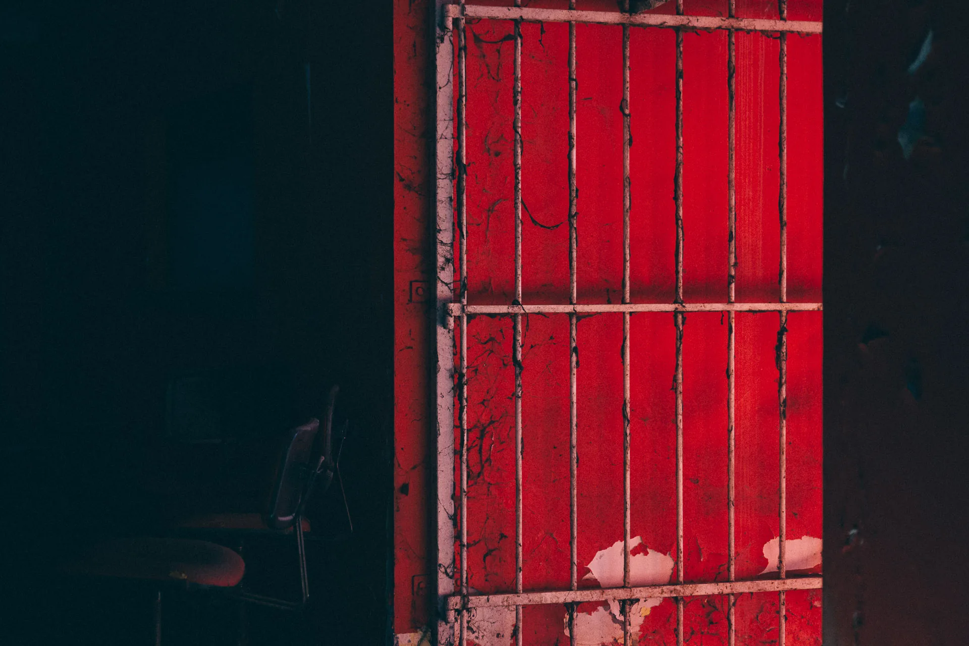 A red door glowing in a dark room
