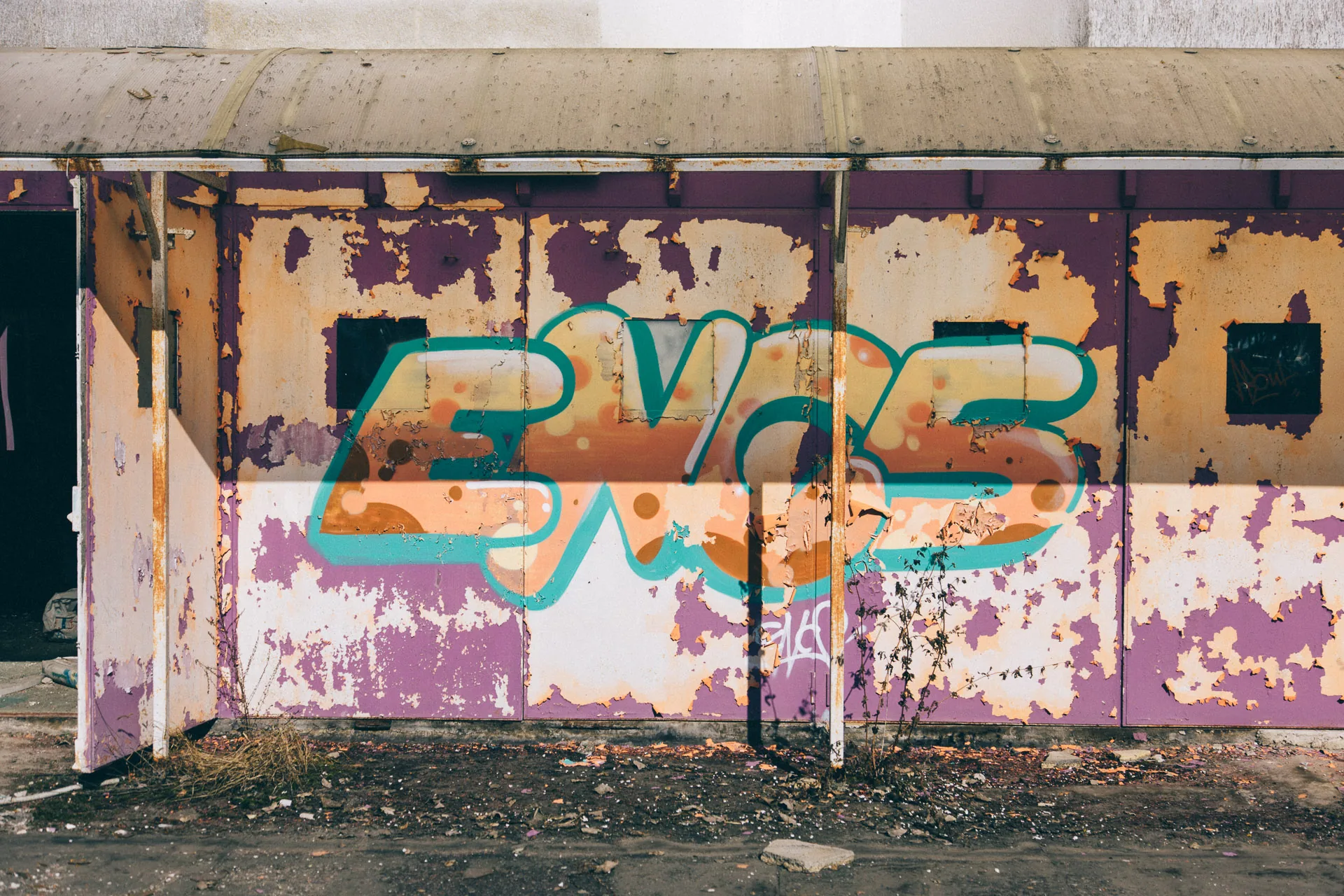 Graffiti on a stained wall in a derelict room