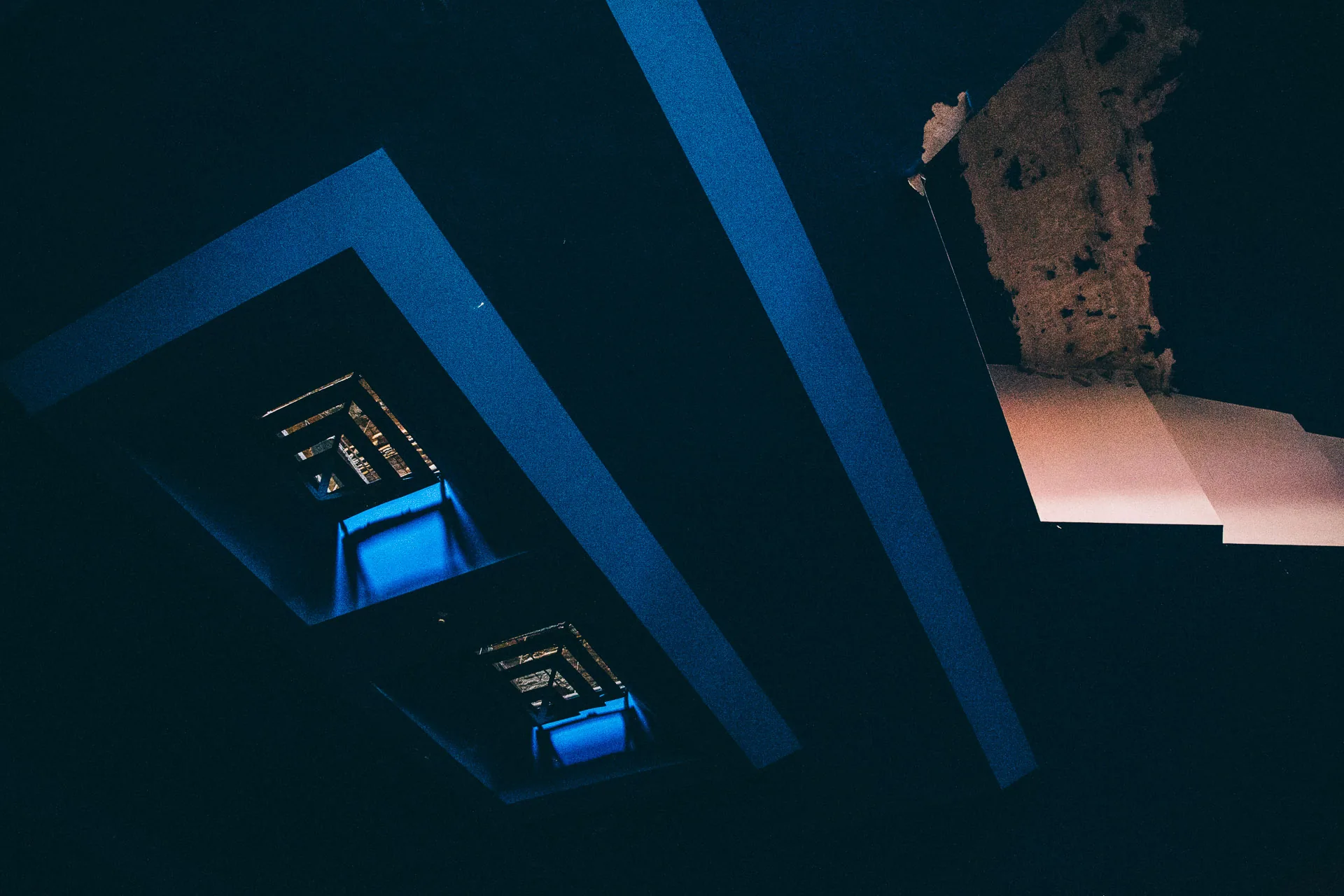 Blue light from a recessed fixture in a dark ceiling
