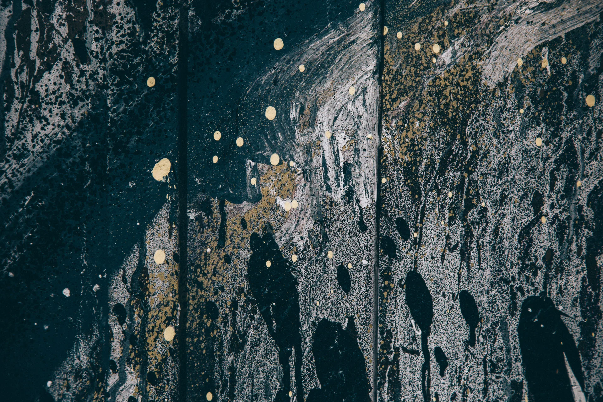 A weathered dark wall streaked with paint