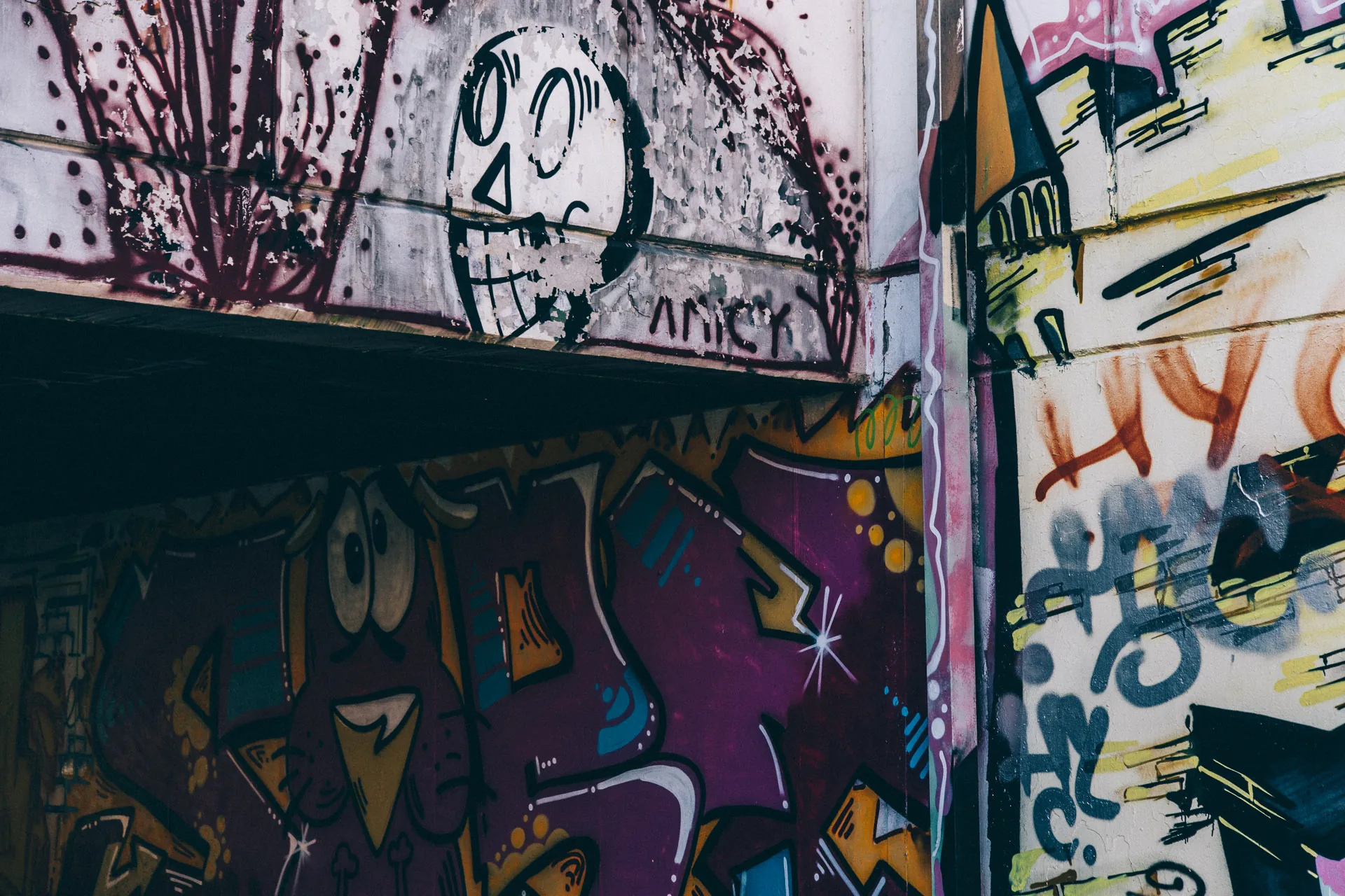 Layered graffiti on a girder and wall