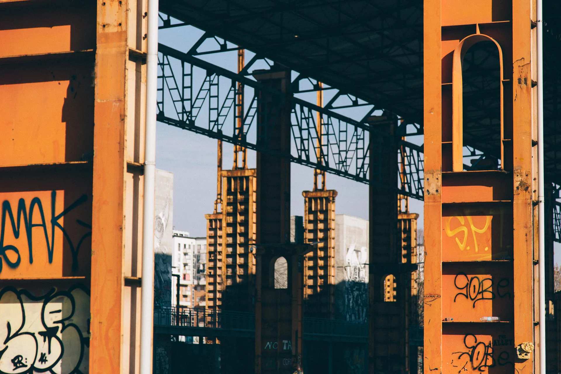 Orange steel columns framing old factory structures